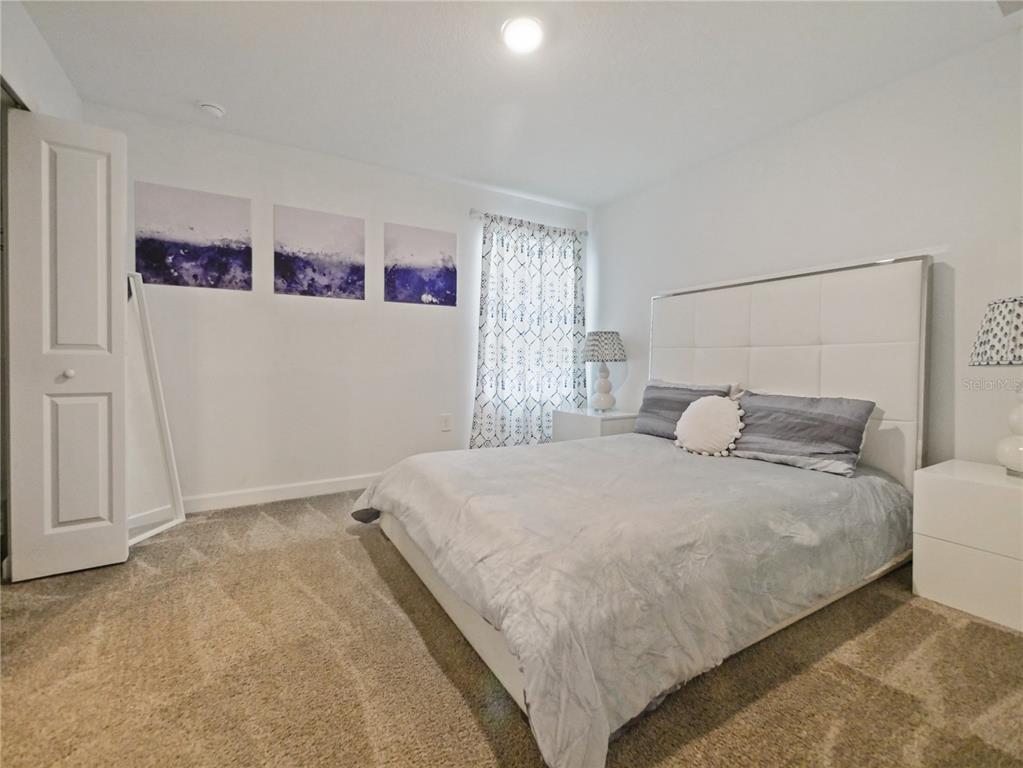 9084 Sommerset Hills Drive Davenport, FL 33896 - Photo 36 of 63 a bedroom with a bed and wall painting