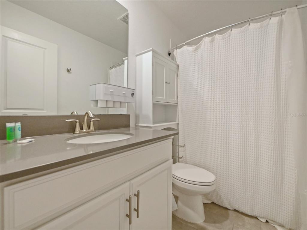 9084 Sommerset Hills Drive Davenport, FL 33896 - Photo 39 of 63 a bathroom with a granite countertop sink mirror vanity and toilet