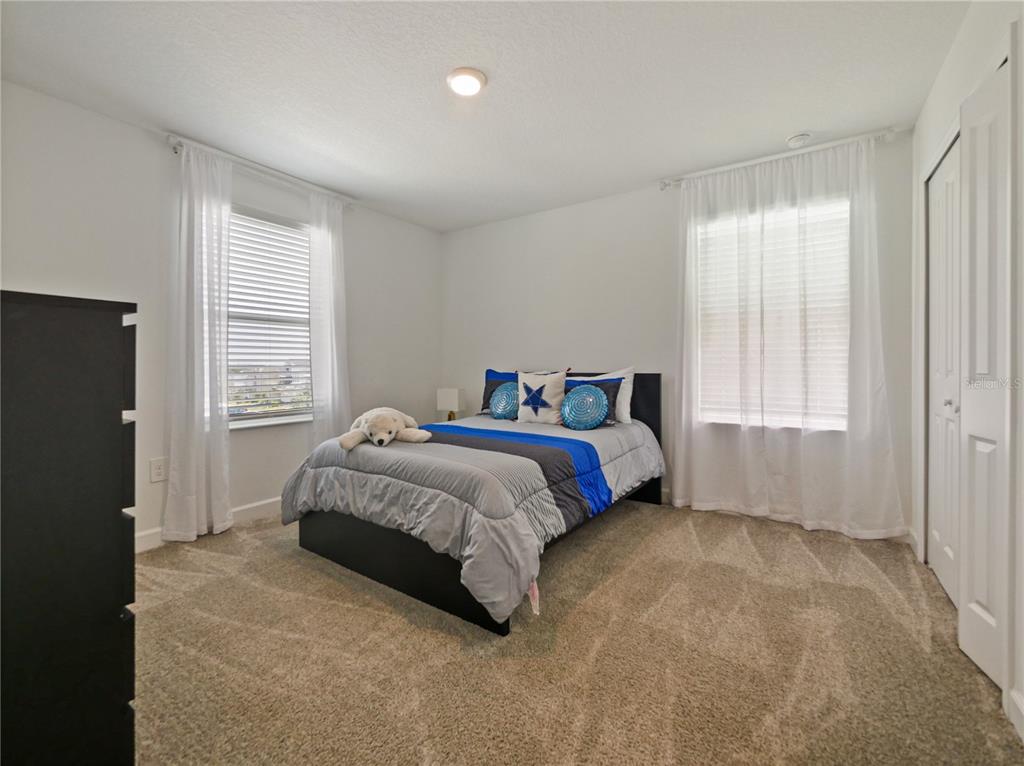 9084 Sommerset Hills Drive Davenport, FL 33896 - Photo 41 of 63 a spacious bedroom with a bed and a window