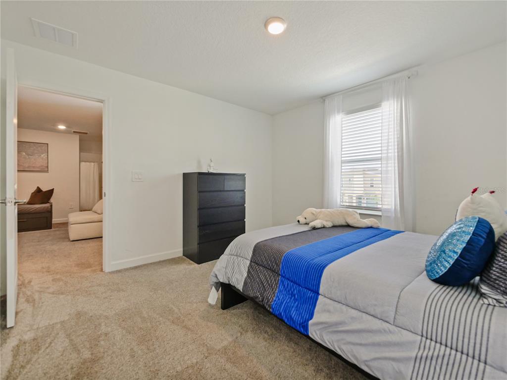 9084 Sommerset Hills Drive Davenport, FL 33896 - Photo 42 of 63 a bedroom with a bed and a cabinets