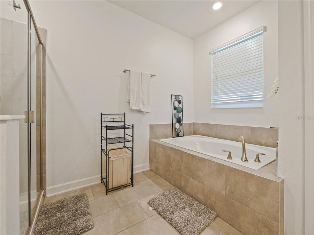 9084 Sommerset Hills Drive Davenport, FL 33896 - Photo 43 of 63 a bathroom with a bathtub and a shower