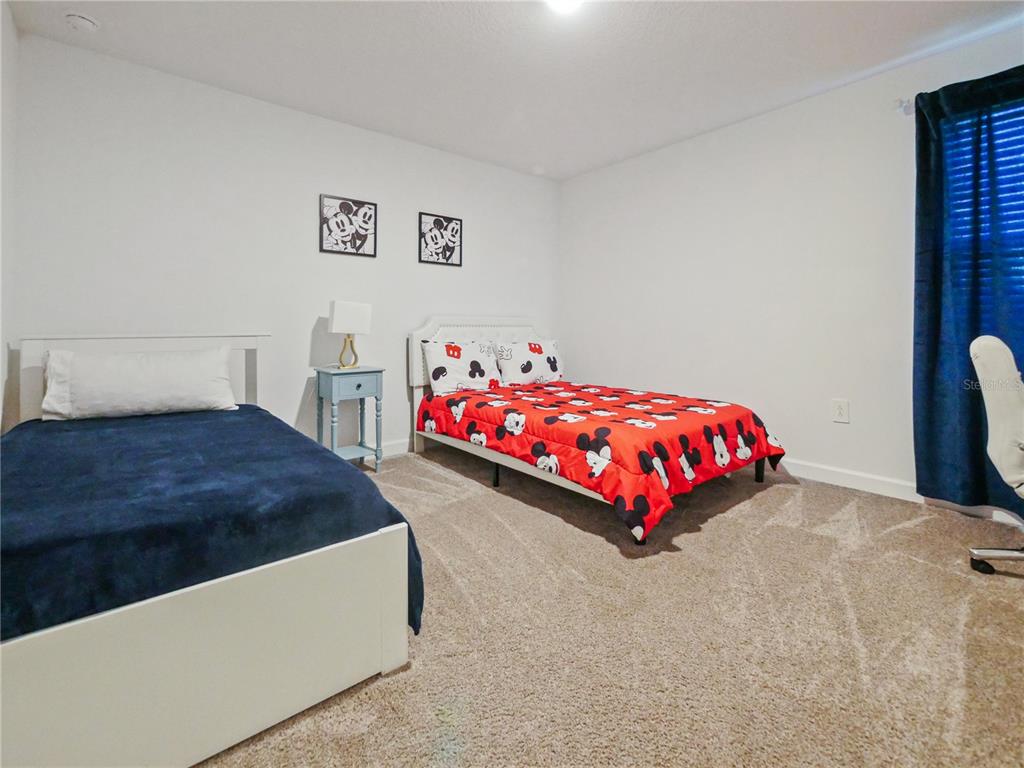 9084 Sommerset Hills Drive Davenport, FL 33896 - Photo 47 of 63 a bedroom with a bed and a table