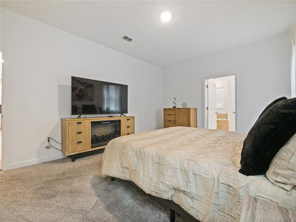 9084 Sommerset Hills Drive Davenport, FL 33896 - Photo 57 of 63 a bedroom with a bed and a flat screen tv