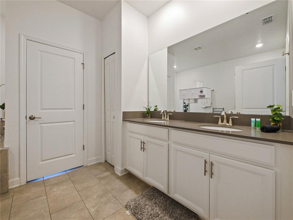 9084 Sommerset Hills Drive Davenport, FL 33896 - Photo 58 of 63 a bathroom with a sink and a mirror