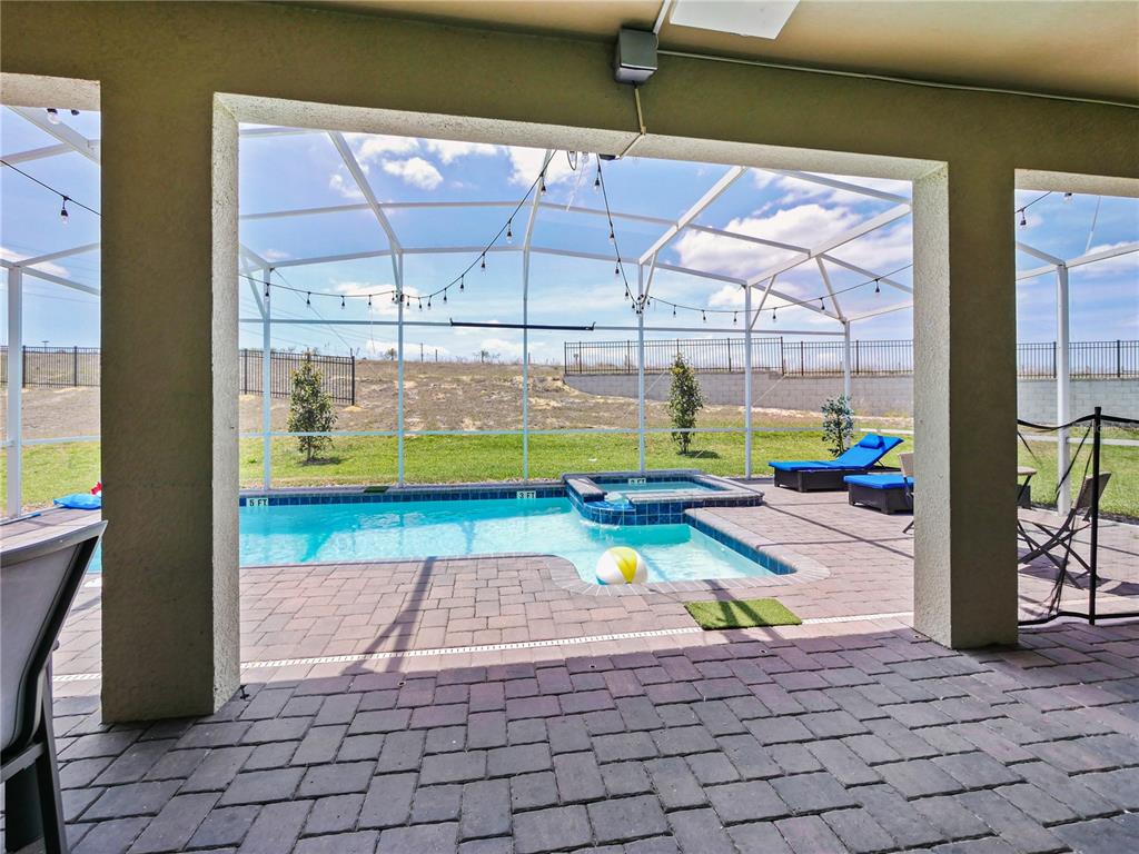 9084 Sommerset Hills Drive Davenport, FL 33896 - Photo 59 of 63 a view of a swimming pool with a lounge chair
