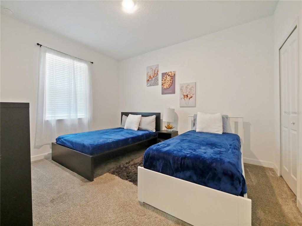 9084 Sommerset Hills Drive Davenport, FL 33896 - Photo 10 of 63 a bedroom with two beds and a window