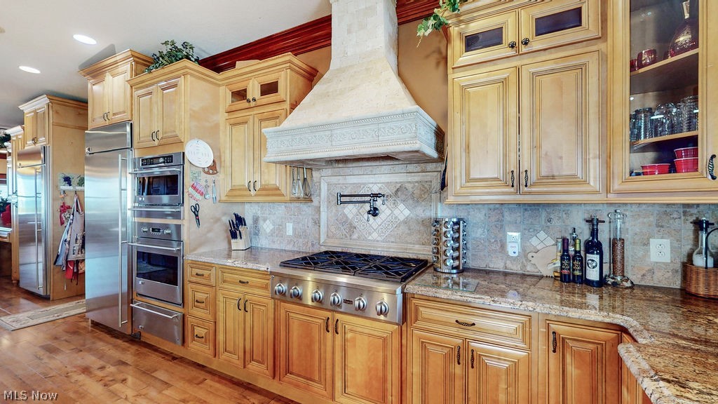 1431 Cedar Point Road Sandusky, OH 44870 - Photo 8 of 50 Kitchen featuring custom range hood, appliances with stainless steel finishes, a warming drawer, and tasteful backsplash