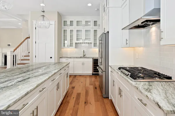 a large kitchen with a stove and white cabinets