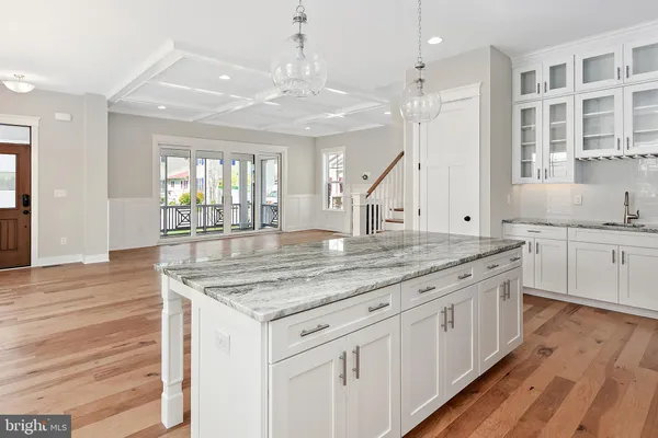 a kitchen with stainless steel appliances granite countertop a kitchen island a stove and a wooden floors