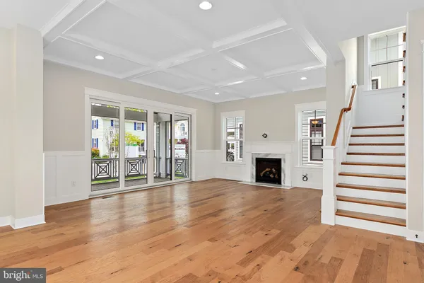 a view of a livingroom with wooden floor and a fireplace