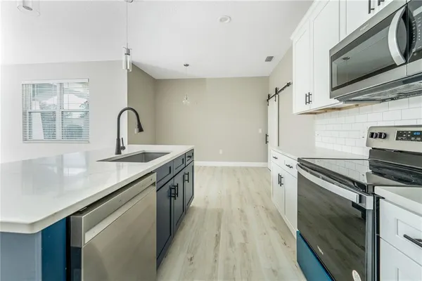 a kitchen with a sink stove and microwave