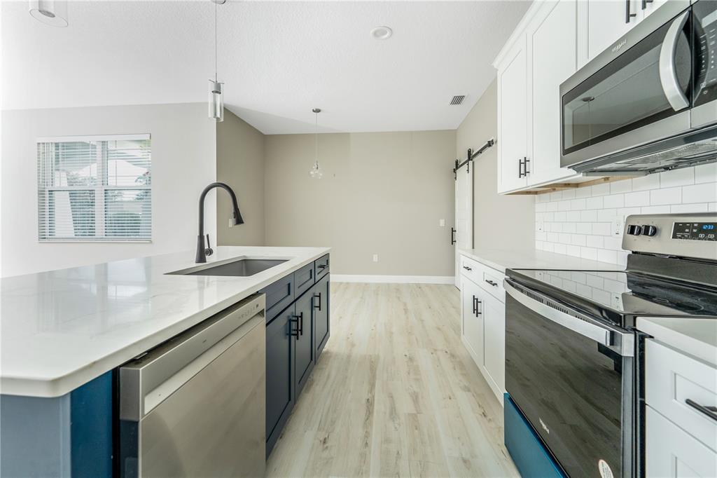 1011 Johnston Road Southeast Palm Bay, FL 32909 - Photo 13 of 47 a kitchen with a sink stove and microwave