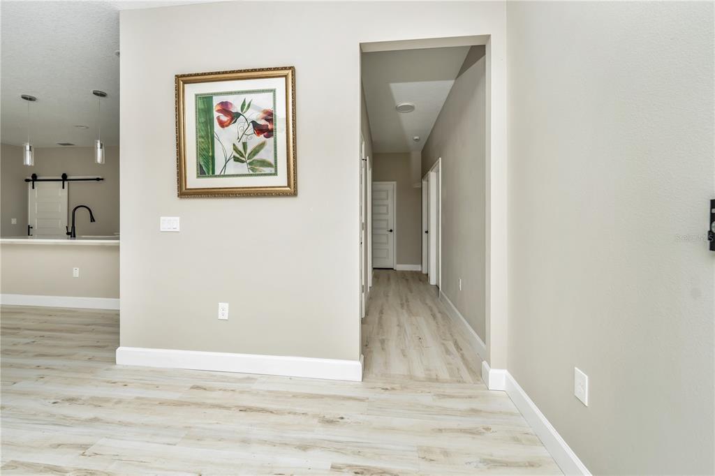 1011 Johnston Road Southeast Palm Bay, FL 32909 - Photo 14 of 47 a view of a hallway with wooden floor and paintings on the wall