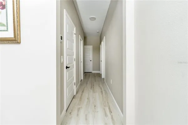 a view of a hallway with wooden floor