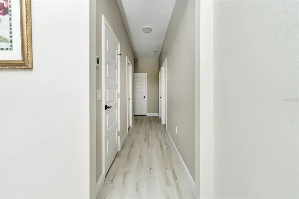a view of a hallway with wooden floor