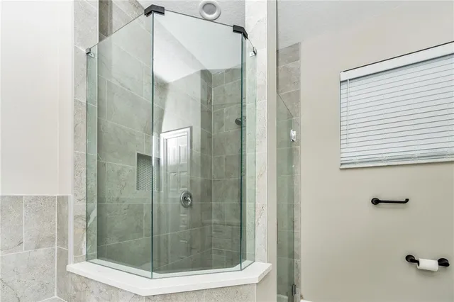 a bathroom with a granite countertop toilet a sink a mirror and a window