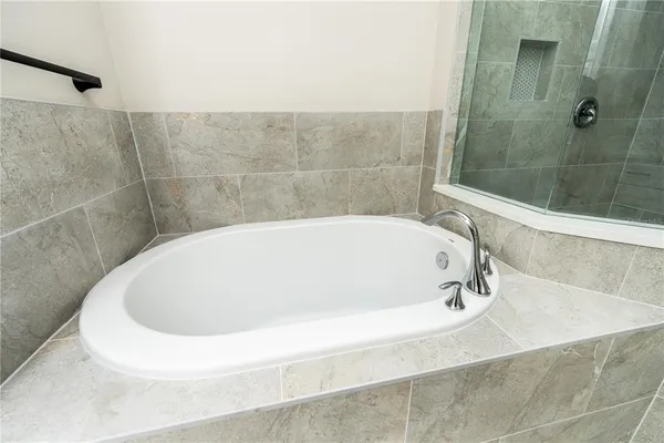 a white bath tub sitting in a bathroom and shower