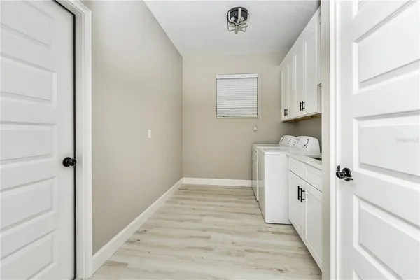 a kitchen with white cabinets and white appliances