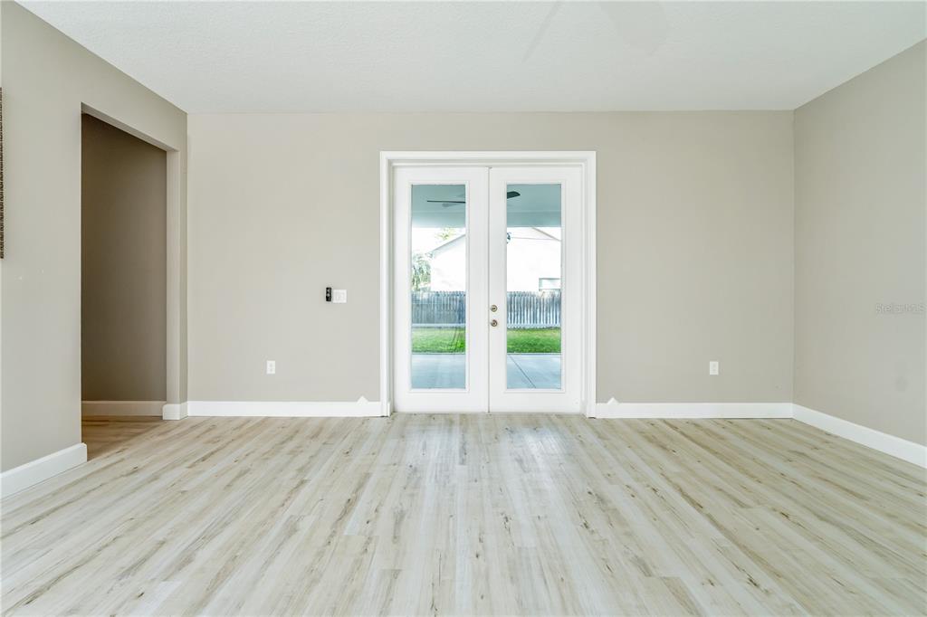 1011 Johnston Road Southeast Palm Bay, FL 32909 - Photo 4 of 47 a view of an empty room with wooden floor and a window