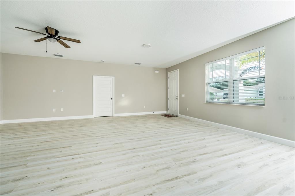 1011 Johnston Road Southeast Palm Bay, FL 32909 - Photo 5 of 47 a view of an empty room with a window and wooden floor