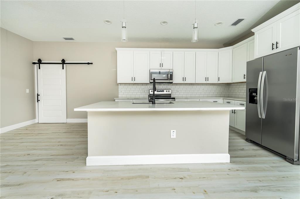1011 Johnston Road Southeast Palm Bay, FL 32909 - Photo 9 of 47 a view of kitchen with stainless steel appliances granite countertop a stove a refrigerator a sink dishwasher and a refrigerator with wooden floor