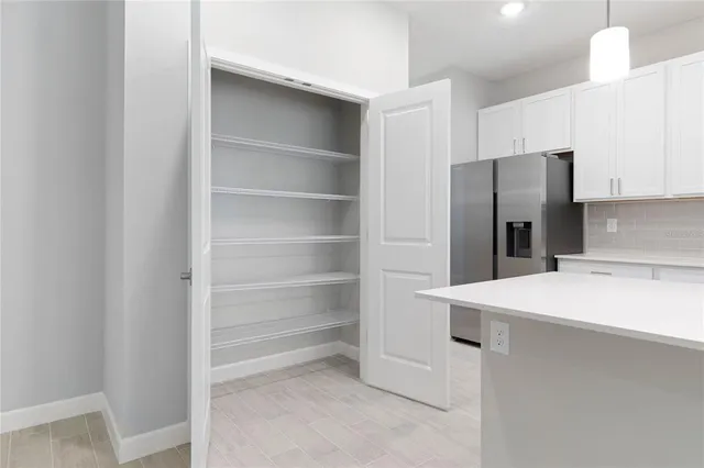 a kitchen with a refrigerator and white cabinets