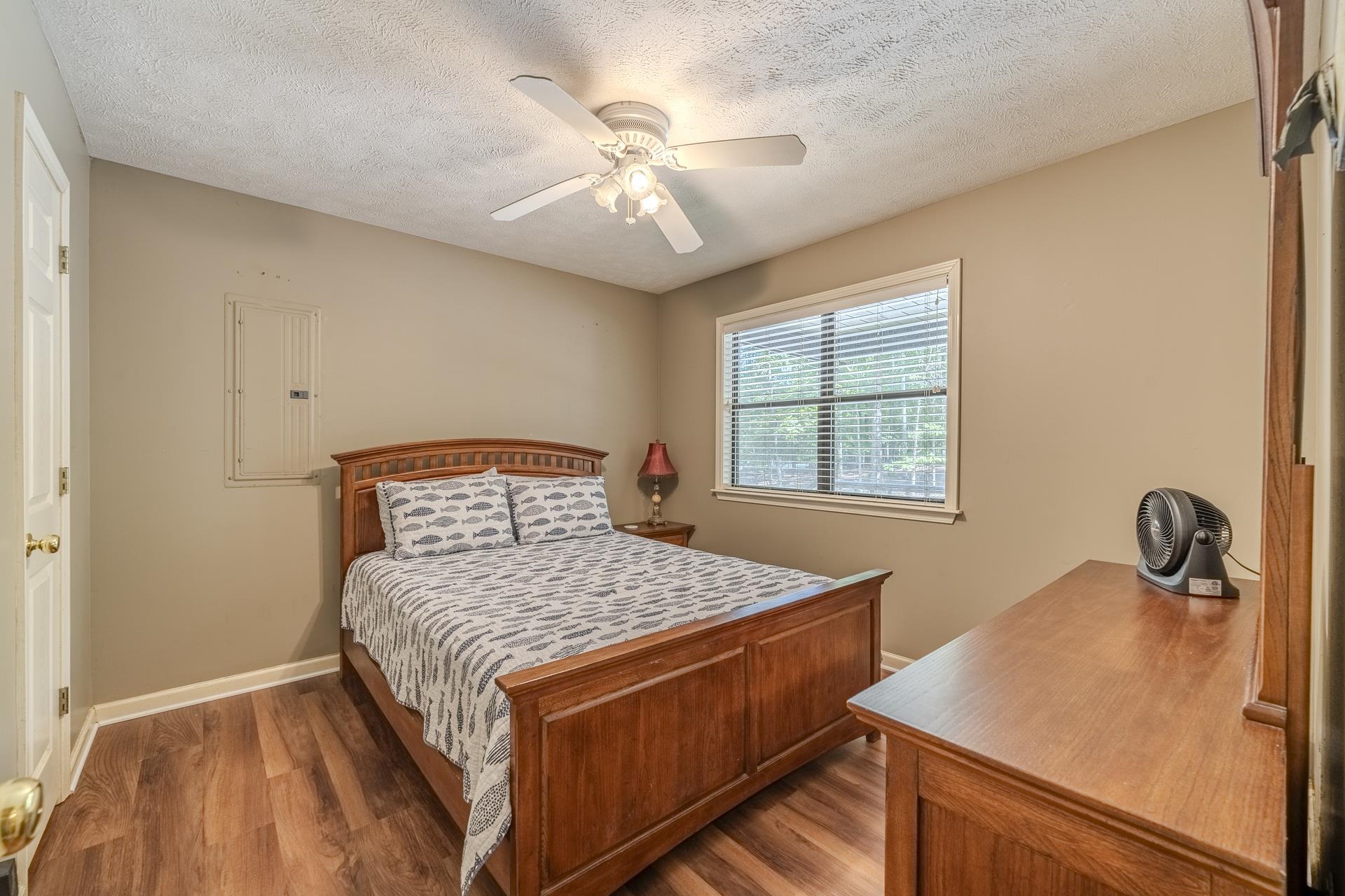 435 Murray Lane Counce, TN 38326 - Photo 18 of 34 Room with wood-finish flooring, neutral wall paint, and a white ceiling fan with integrated lighting