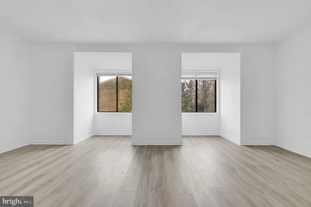 an empty room with wooden floor and a window
