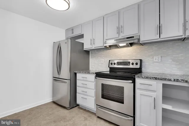 a kitchen with refrigerator stove and white cabinets