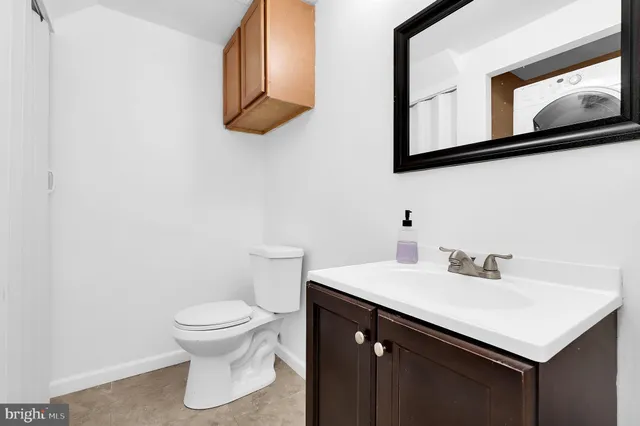 a bathroom with a sink vanity and toilet