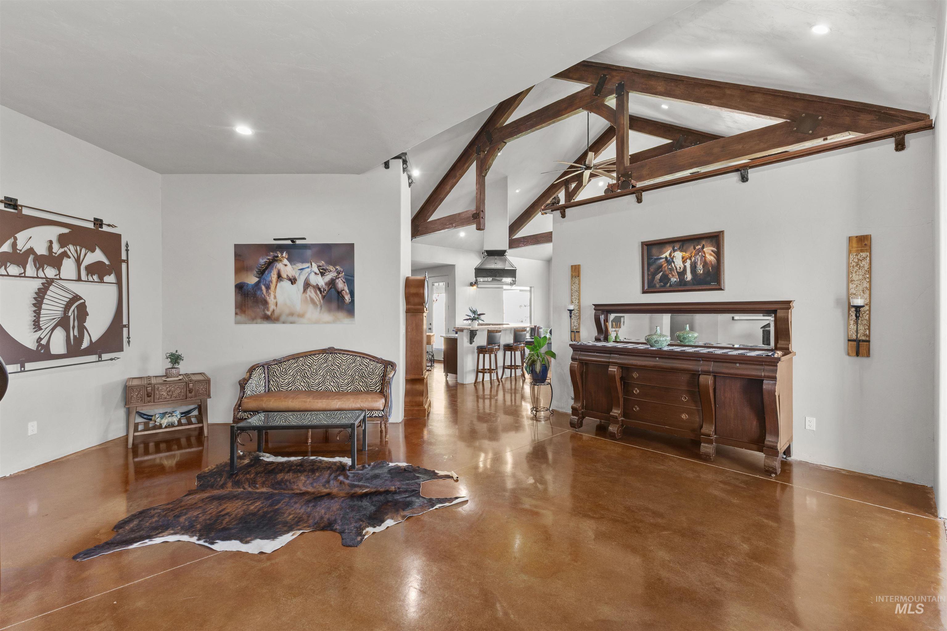 1030 Desert Glen Road Adrian, OR 97901 - Photo 17 of 47 Vaulted ceiling with exposed wood beams, stained concrete flooring, recessed lighting, and a partial view of a kitchen with a range hood