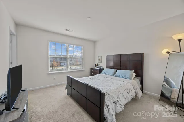 a bedroom with a bed window and a flat screen television