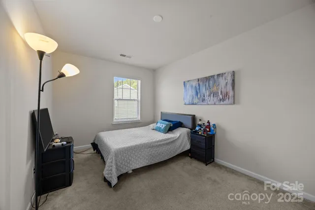 a view of a backyard with chairs and iron fence