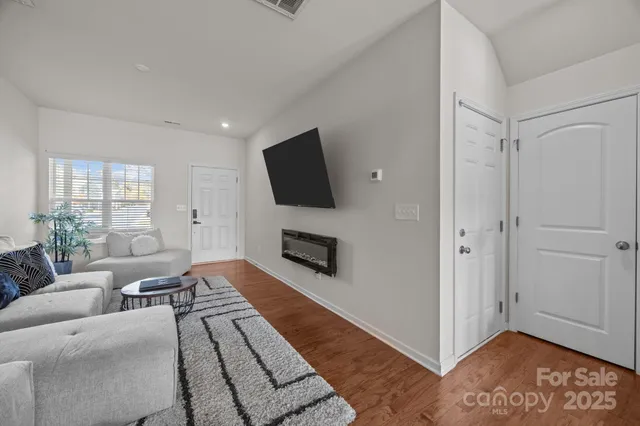a living room with furniture wooden floor and a flat screen tv