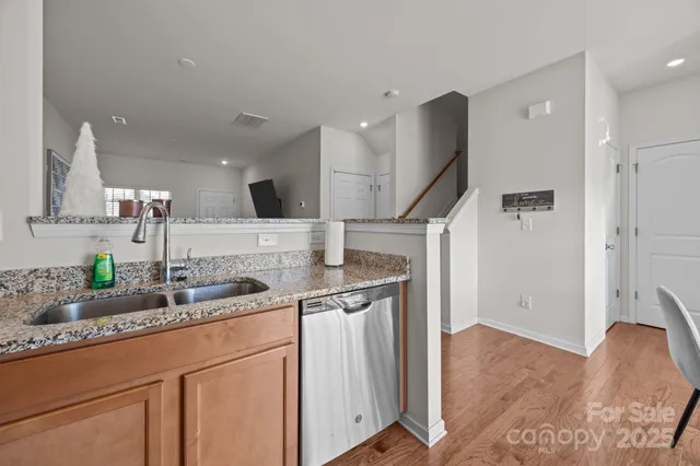 a kitchen with stainless steel appliances granite countertop a sink and a refrigerator