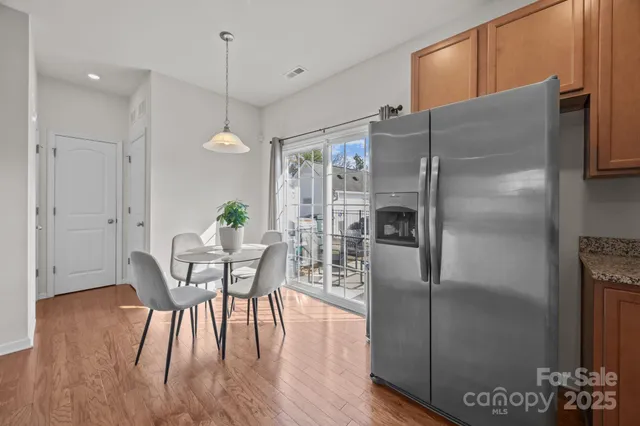a kitchen with stainless steel appliances a refrigerator a table and chairs