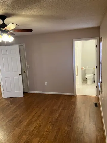 a view of a room with wooden floor and a bathroom