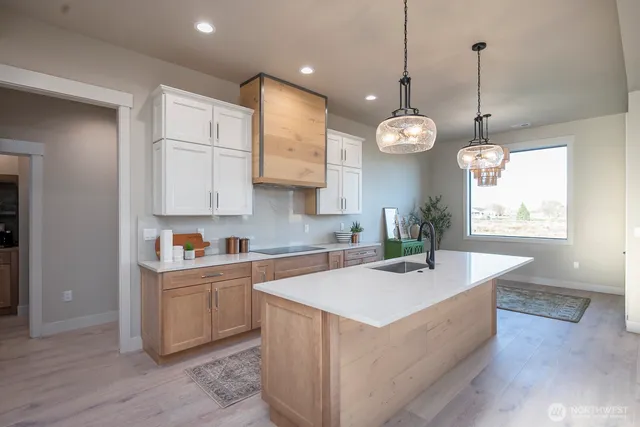a kitchen with kitchen island a sink stainless steel appliances and chandelier