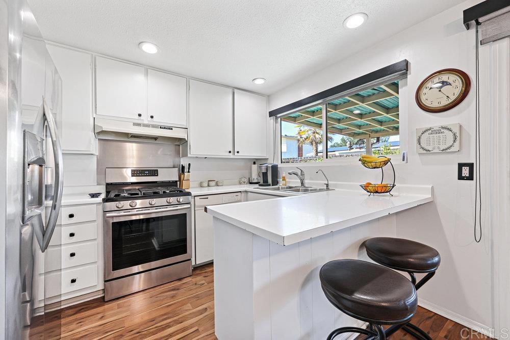 8450 Carlton Oaks Drive Santee, CA 92071 - Photo 13 of 30 a kitchen with a sink a stove and a window