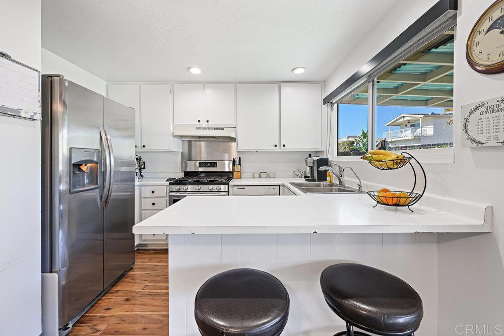 8450 Carlton Oaks Drive Santee, CA 92071 - Photo 14 of 30 a kitchen with stainless steel appliances a sink a stove a refrigerator a washer and dryer