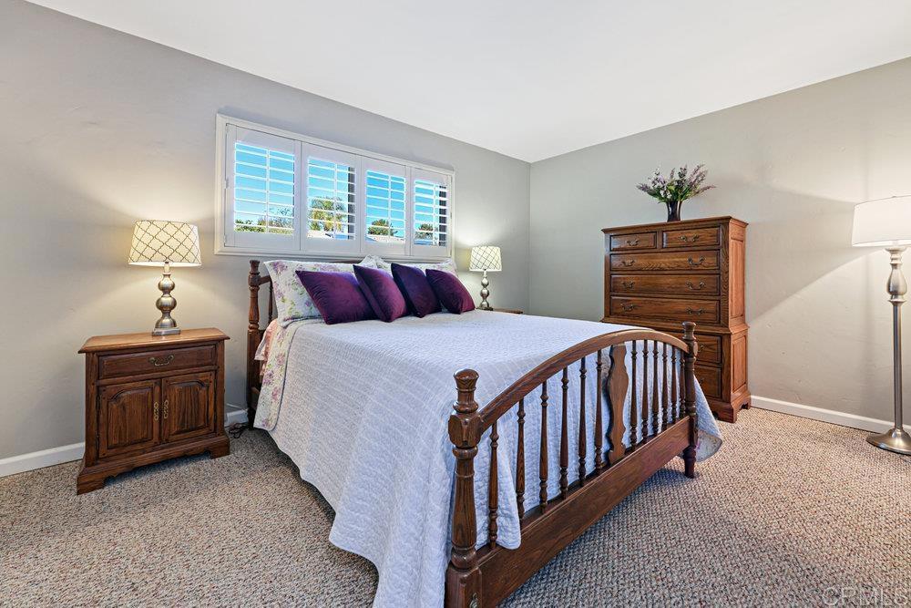 8450 Carlton Oaks Drive Santee, CA 92071 - Photo 17 of 30 a bedroom with a bed and a chandelier