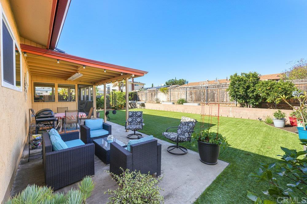 8450 Carlton Oaks Drive Santee, CA 92071 - Photo 26 of 30 a view of a patio with couches chairs potted plants and a palm tree