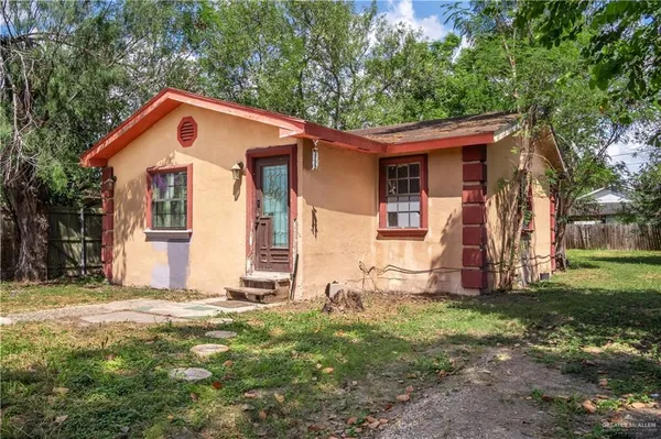 a view of a house with backyard and trees