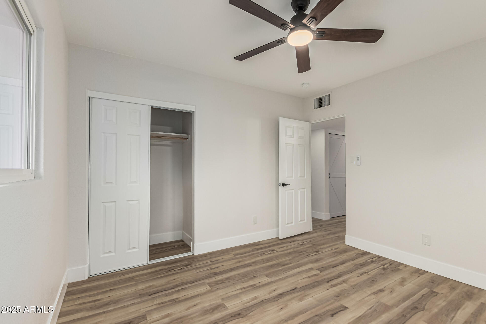3111 North 34th Street Phoenix, AZ 85018 - Photo 50 of 76 an empty room with wooden floor a ceiling fan and closet