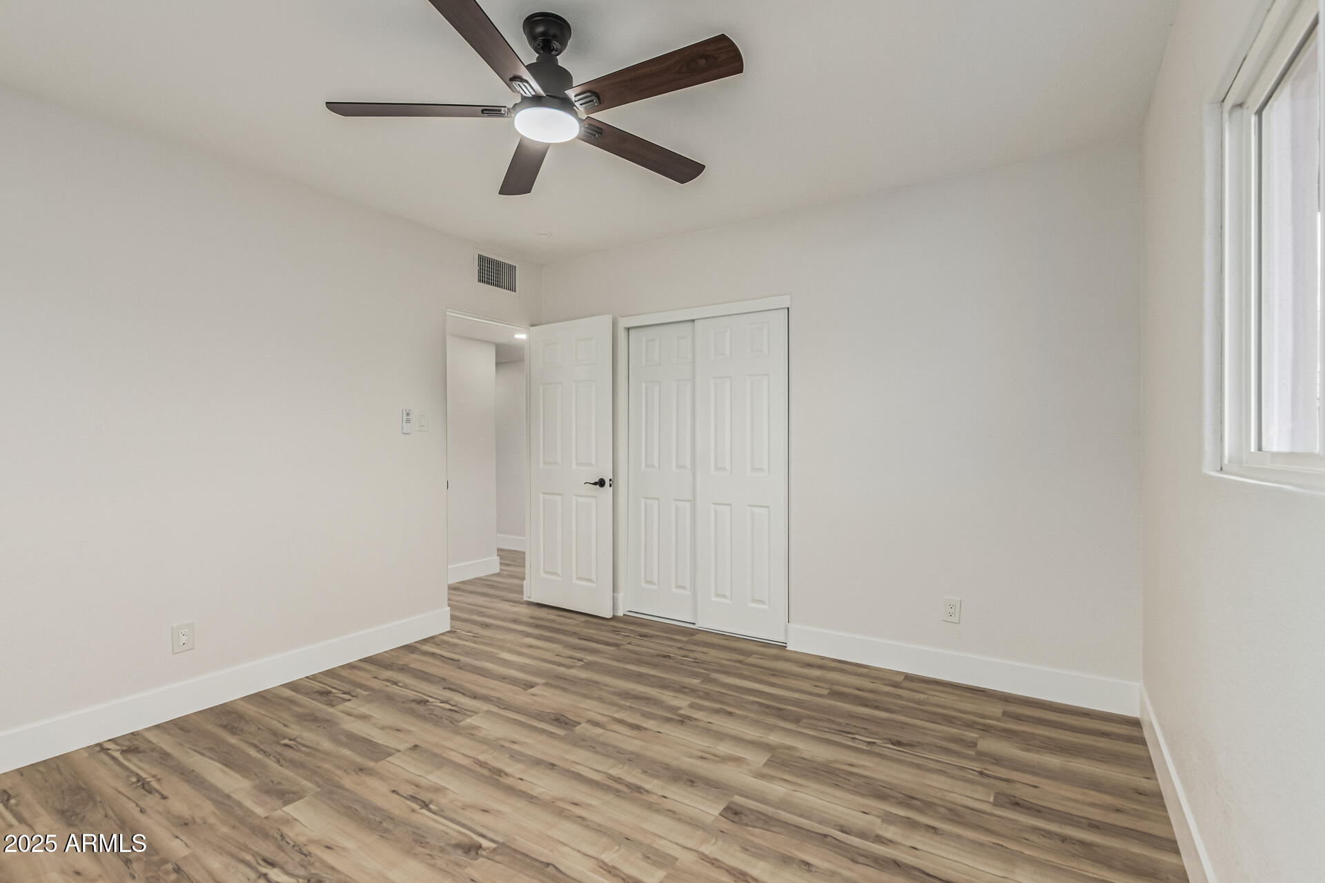 3111 North 34th Street Phoenix, AZ 85018 - Photo 58 of 76 a view of empty room with wooden floor and fan