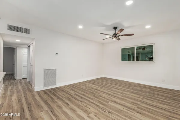 a large kitchen with stainless steel appliances kitchen island granite countertop a refrigerator a stove and a wooden floors