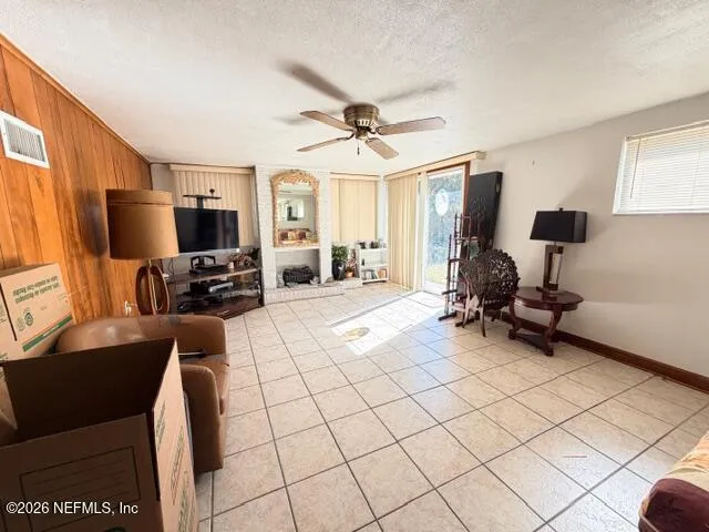 a living room with furniture a flat screen tv and a window