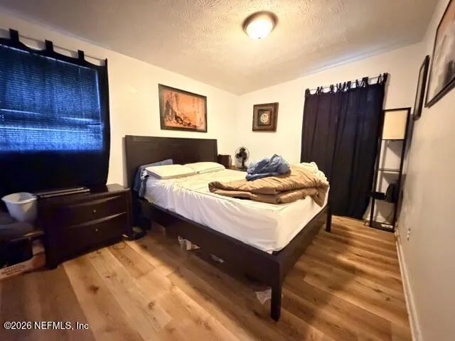 a bedroom with a bed and wooden floor