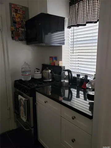 a kitchen with granite countertop stainless steel appliances a sink dishwasher a stove and a refrigerator