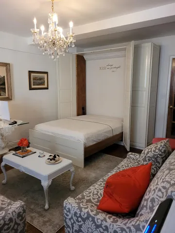 a bedroom with furniture and a chandelier